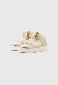 Baskets montantes en cuir blanc avec des accents métalliques dorés, présentant un système de laçage à l'avant et une sangle Velcro. Design texturé avec des perforations.