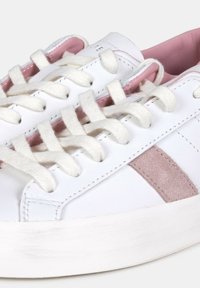 Sneaker bianche in pelle con accenti rosa chiaro, caratterizzate da una striscia in suede, lacci rotondi e una suola in gomma bianca testurizzata.