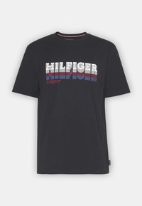 Camiseta de algodón negra de manga corta que presenta un audaz logo "HILFIGER" en blanco y rojo con efectos de sombra a rayas azules y cuello redondo.