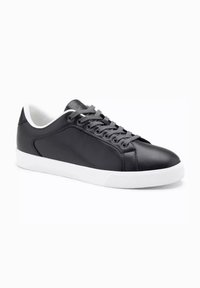 Czarne skórzane trampki mają gładką powierzchnię, szare sznurówki i białą gumową podeszwę z teksturowanym wzorem. Minimalistyczny design i sportowy styl.