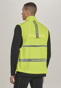 Gelbe Warnweste mit reflektierenden Streifen, ausgestattet mit hohem Kragen, offenem Rücken und "ENDURANCE"-Markenlogo im unteren Bereich.