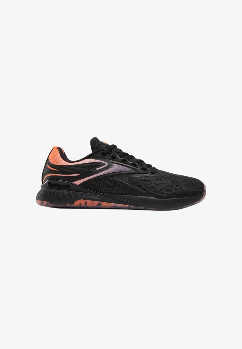 Baskets de sport noires et orange avec empeigne en mesh, lacets et semelle à motifs, présentées de profil sur fond blanc.
