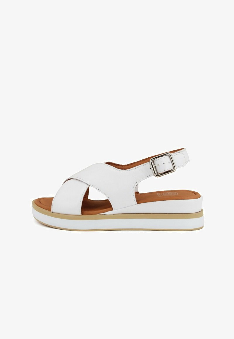 Sandalo in pelle bianca con design incrociato e cinturino regolabile alla caviglia. Presenta una soletta imbottita marrone e una suola impilata bianca.