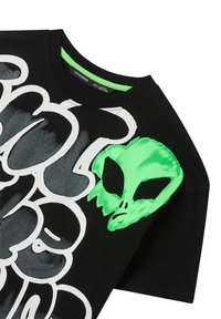 T-shirt in cotone nero con una grande grafica bianca e un design di volto di alieno verde sul lato sinistro. Collo rotondo, maniche corte.
