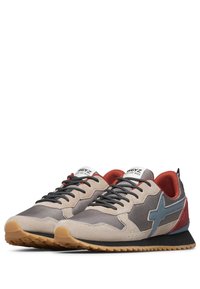 Le sneaker presentano una tomaia in suede grigia e beige con un accento a forma di stella blu, un rivestimento rosso e lacci neri su una suola in gomma marrone.