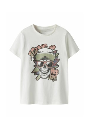 Chemise blanche à manches courtes avec un dessin d'un crâne portant une casquette et des lunettes de soleil, texte « Have a nice day ! » en police stylisée.