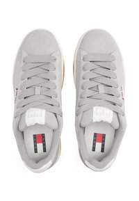 Gray suede sneakers with flat laces, rubber outsoles, and a logo. Features a white midsole and a fabric inner lining with branding.