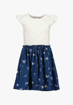 Biała sukienka z krótkim rękawem, z haftowanym ażurowym wzorem na górze, granatowa spódnica z kwiatowym wzorem w białym i niebieskim kolorze. Marszczona talia.