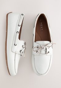 Hvide læderloafer med tekstureret finish, brun gummisål og snørefinisher med metaløjer. Glat inderfor.