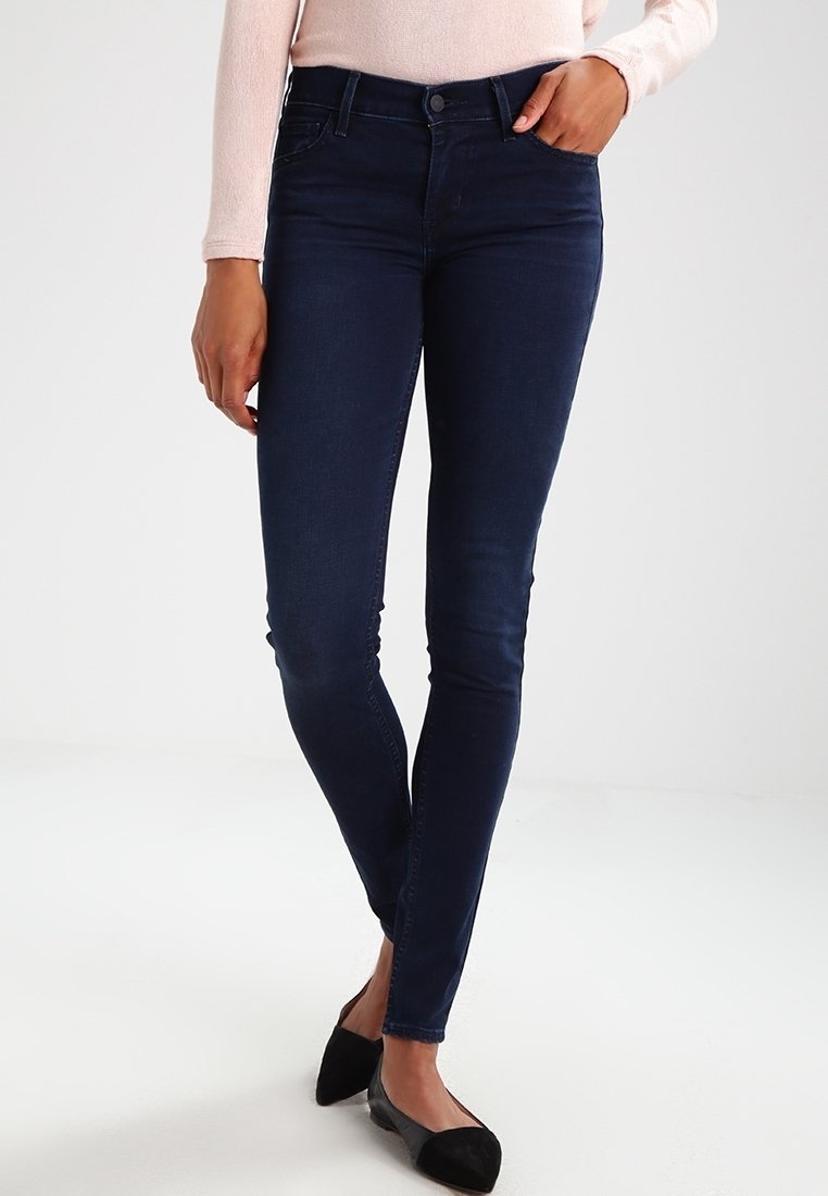 Smala jeans i mörkblå denim med en mjuk textur, standard femficksdesign och en figurnära silhuett. Matchas med svarta ballerinas.