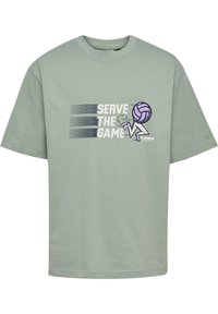 Ljusgrön bomullströja med texten "Serve the Game", en volleybollgrafik i lila och korta ärmar med rund halsringning.