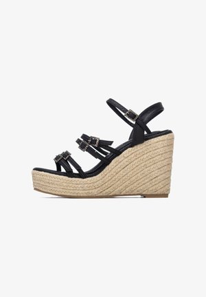 Sandalia negra de cuña con tiras, plataforma envuelta en yute y tres hebillas decorativas en las tiras.