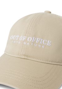 Beige bomulds cap med forhøjet hvid broderet tekst "OUT OF OFFICE INTO NATURE." Glat tekstur med buet skygge og syninger.
