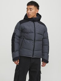 Giubbotto imbottito grigio con accenti neri, dotato di chiusura con zip, cappuccio e imbottitura trapuntata. Il design include tasche laterali e polsini elasticizzati.