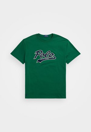Camiseta de algodón verde con un gran gráfico del logo en blanco y marino de "Polo" y el texto "RALPH LAUREN" debajo. Cuello redondo y mangas cortas.