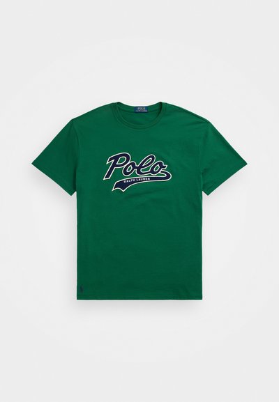 Πράσινο βαμβακερό μπλουζάκι με μεγάλο λευκό και ναυτικό μπλε γραφικό λογότυπο "Polo" και κείμενο "RALPH LAUREN" από κάτω. Στρογγυλή λαιμόκοψη και κοντά μανίκια.