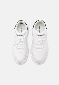 Paire de baskets blanches Karl Lagerfeld avec lacets et bordure noire au talon, vues de dessus sur fond blanc.