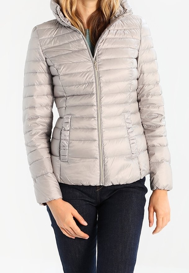 Jasnoszara kurtka puchowa z kapturem, charakteryzująca się poziomą pikowaną fakturą, zamek z przodu i bocznymi kieszeniami, w połączeniu z ciemnymi dżinsami.