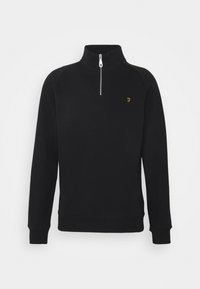 Sudadera negra con cuello alto y cremallera de medio cierre. Puños y dobladillo acanalados. Presenta un pequeño logo amarillo en el lado izquierdo del pecho. Textura suave.