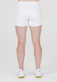 Vita sportshorts med elastisk midja. Slät textur, kort längd och i kombination med vita sportskor med grå detaljer.