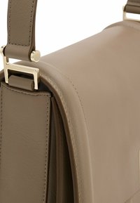 Tan leather handbag with a smooth texture, featuring a gold-tone hardware clasp and a sleek, minimalist design.