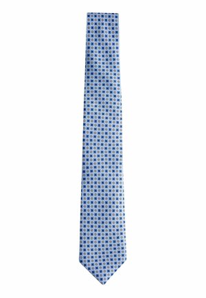 Light blue tie featuring a repeating geometric pattern in darker blue, red, and white. Made of smooth fabric, with a narrow shape and pointed tip.