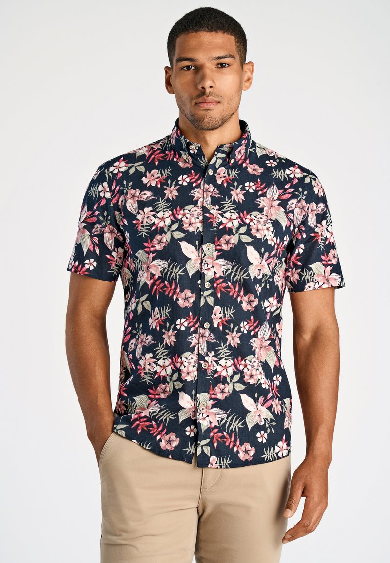 Koszula z krótkim rękawem zapinana na guziki, w granatowym tle, z kwiatującym wzorem w odcieniach różu, kremu i zieleni. Wykonana z lekkiego materiału.