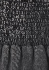 Tissu gris foncé avec une section supérieure texturée plissée et un bas plissé. Le matériau semble doux avec un léger éclat et des coutures visibles.