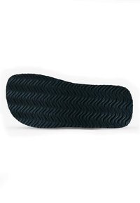 Black rubber sole with textured wavy pattern, rounded toe, and slightly raised edges. Flat and flexible design suitable for various footwear.