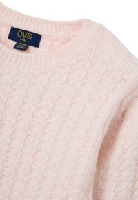 Helles rosa gestricktes Sweatshirt mit einem gerippten Rundhalsausschnitt. Verfügt über ein strukturiertes Muster und ein Etikett mit "OVS kids". Weiches, kuscheliges Material.
