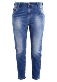 Jean en denim bleu avec un délavage usé, jambes fuselées et design à cinq poches. Comprend une fermeture à bouton à l'avant et des passants de ceinture.