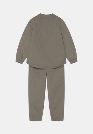 Olivgrünes, gesteppte Langarmjacke und passender Hosen-Set mit gerippten Bündchen und elastischen Beinabschlüssen am Knöchel, von hinten gezeigt.