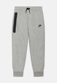 Grå joggingbyxor i mjukt tyg med åtsittande mudd och elastisk midjeresår, med en ficka med dragkedja och en svart Nike-logotyp.