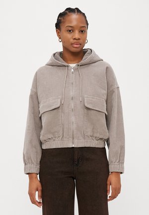 Gekürzte graue Cordjacke mit Kapuze, Frontreißverschluss und zwei Brusttaschen. Verfügt über einen elastischen Saum und elastische Bündchen. Glatte Textur.