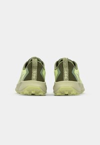 Des chaussures de trail running vertes et jaunes avec une tige en mesh respirant, un dos texturé et une semelle extérieure robuste pour une meilleure traction.