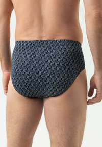 Slip de bain noir avec un motif répétitif d'éléphants blancs, avec une texture lisse et une coupe ajustée.