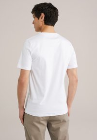 Tricou alb cu mânecă scurtă, fabricat din bumbac, având un gât tip crew neck și o textură netedă. Design simplu, fără modele vizibile.