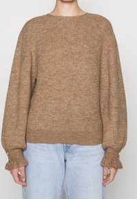 Maglione marrone lavorato a maglia con scollatura rotonda, maniche a palloncino e polsini arricciati con dettagli di bottoni dorati. Materiale testurizzato.