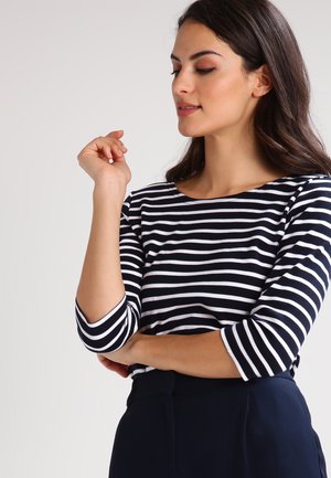 Haut à rayures bleu marine et blanc à manches longues avec un col bateau et des manches trois-quarts, fabriqué à partir d'un tissu doux et léger.