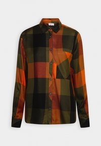 Chemise à manches longues boutonnée avec large motif à carreaux noir, vert, orange et rouille, avec une poche poitrine.