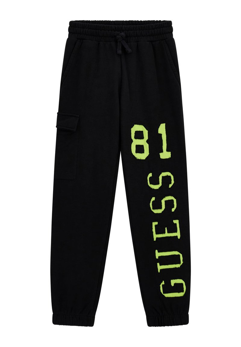 Pantalons de survêtement noirs avec taille élastique, ornés d'un graphique imprimé "GUESS 81" en vert fluo et d'une poche cargo sur le côté. Texture de tissu douce.