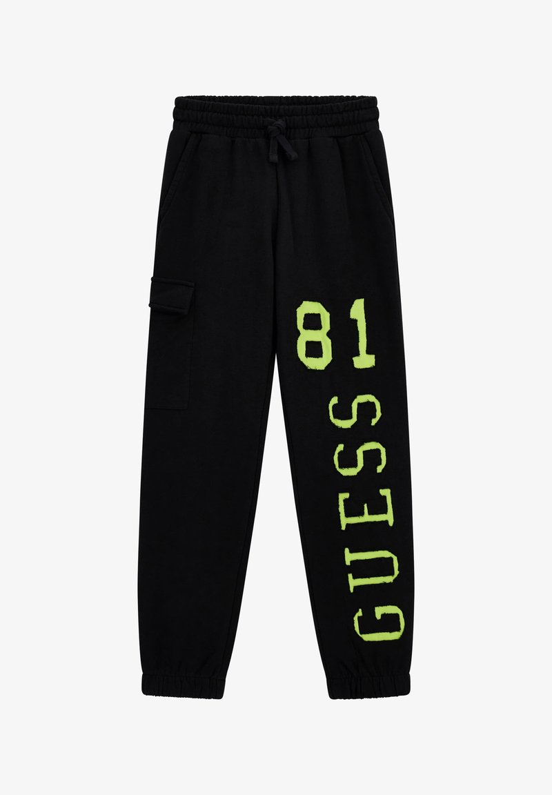 Czarne dresy z elastycznym paskiem w talii, z neonowo zielonym nadrukiem "GUESS 81" oraz boczną kieszenią typu cargo. Miękka tekstura materiału.