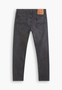 Jeans de mezclilla negra con un ajuste slim. Cuenta con dos bolsillos traseros y una parche de cuero marrón en la cintura con el logo de la marca. Textura suave.
