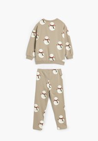 Beige pyjamasæt bestående af en langærmet bluse og bukser. Pyntet med gentagne snemandsmønstre i hvide, røde og grønne nuancer.