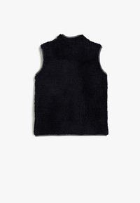 Gilet nero senza maniche con una texture morbida, colletto alto e bordi grigi. Materiale soffice e confortevole, ideale per essere indossato a strati.