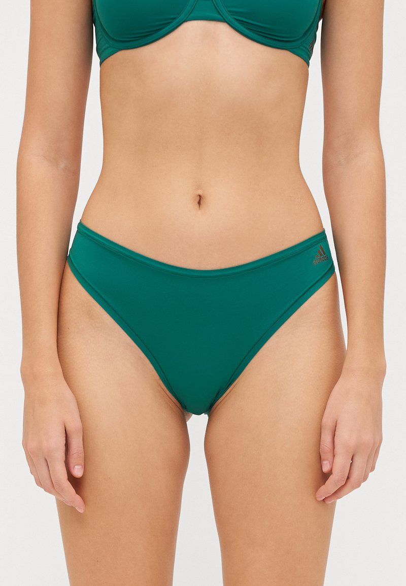 Πράσινο ψηλόμεσο μαγιό μπικίνι από απαλή ύλη με πλαϊνές κοπές και ελάχιστη ραφή. Διαθέτει διακριτική επωνυμία στη ζώνη της μέσης.