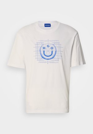 T-shirt bianca in cotone con grafica blu di una faccina sorridente con il testo "HGO", contornata da un motivo a griglia. Maniche corte, scollo rotondo.