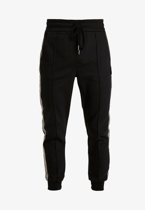 Pantalones jogger negros con cintura elástica, cordón ajustable, franjas laterales con estampado de cuadros y puños en los tobillos.