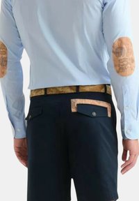 Camicia a maniche lunghe blu chiaro con toppe a gomito stampate a motivi marroni, abbinata a pantaloni corti blu navy e una cintura con stampa mappa testurizzata. Vista da dietro.