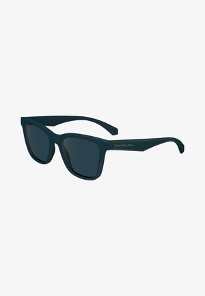 Dunkelblaugrüne rechteckige Sonnenbrille mit dunklen Gläsern. Merkmale sind ein glattes Kunststoffgestell und ein goldenes "Calvin Klein Jeans"-Logo am Bügel.